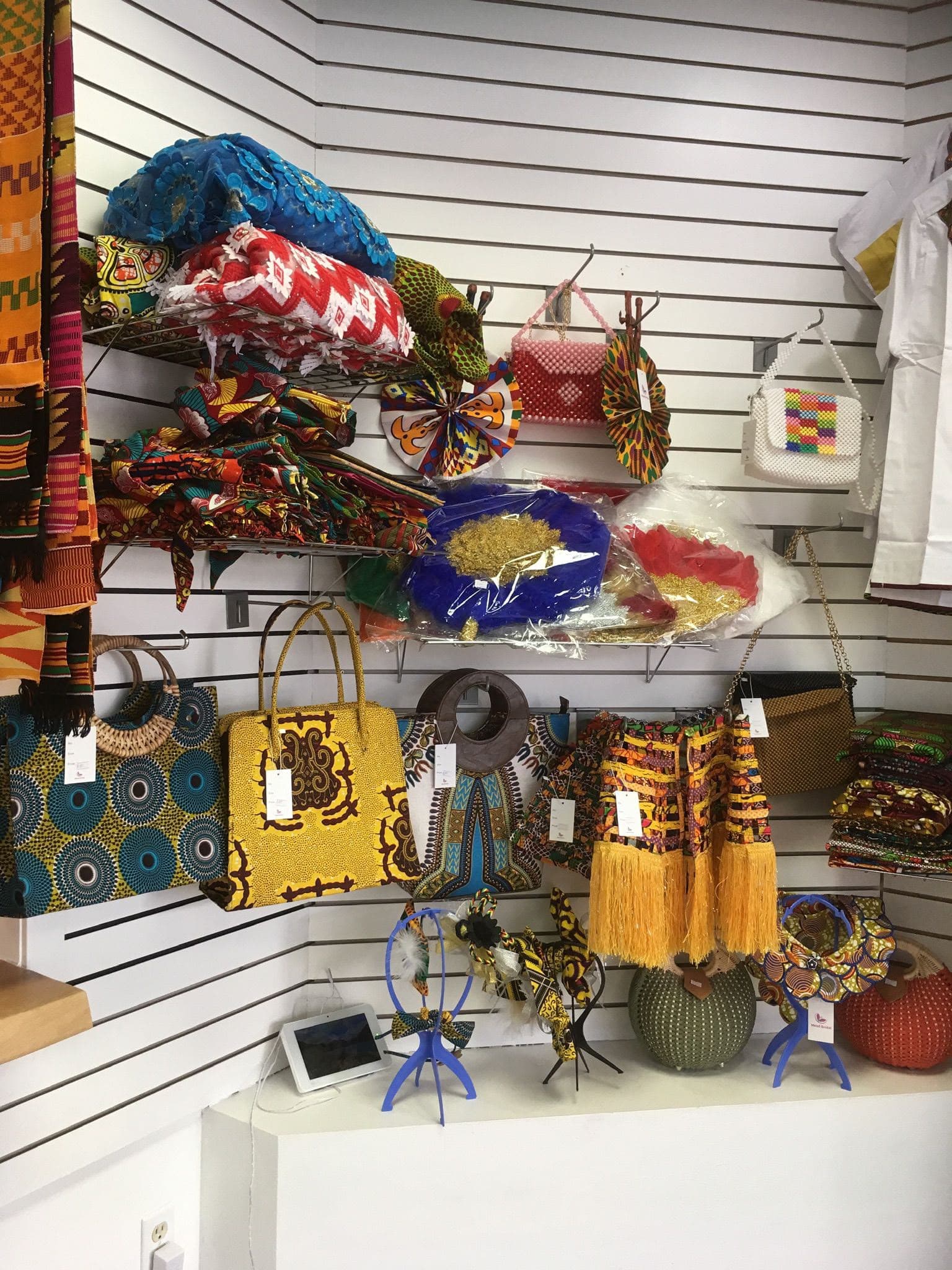 Kente cloth, wax-print handbags, fans and headwraps on the accessories wall